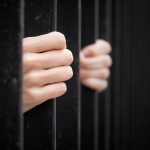 prisoner behind jail bars